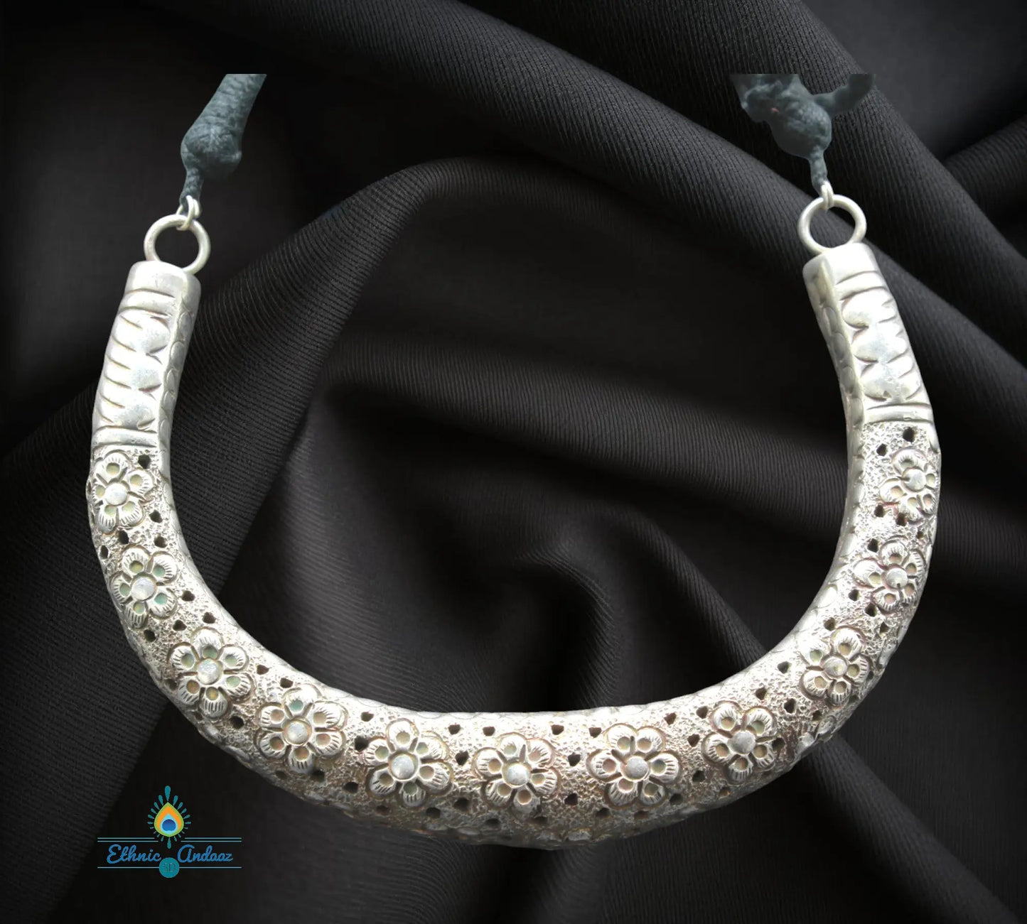 Bhavna oxidised silver hasli set, elegant statement necklace with floral design on a dark background.