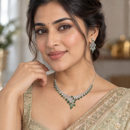 Indian woman wearing an elegant silver necklace featuring green cubic zirconia stones for a sophisticated look.