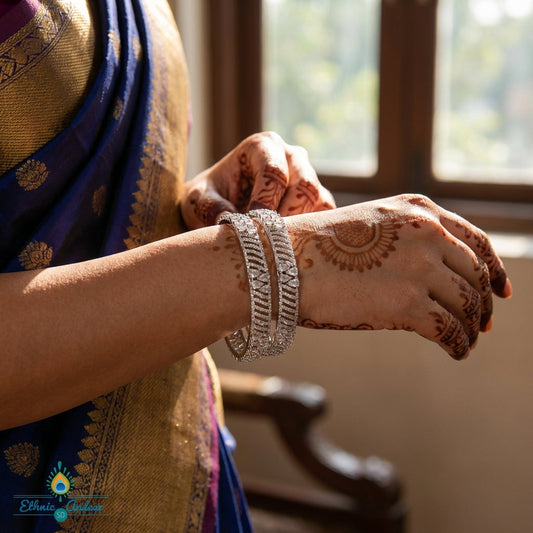 Close-up of a delicate Kamala CZ bangle with a silver finish on dark velvet, highlighting its craftsmanship and sparkling cubic zirconia stones.