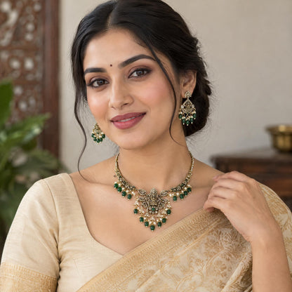 Indian model wearing a traditional 1gm gold Laxmi necklace set paired with matching drop earrings.