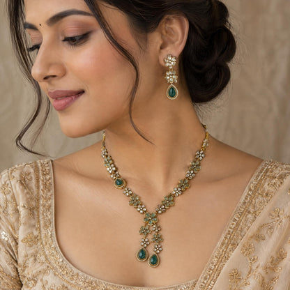 Flower-shaped kundan earring with mint-toned stones worn by an Indian woman against a beige silk background.