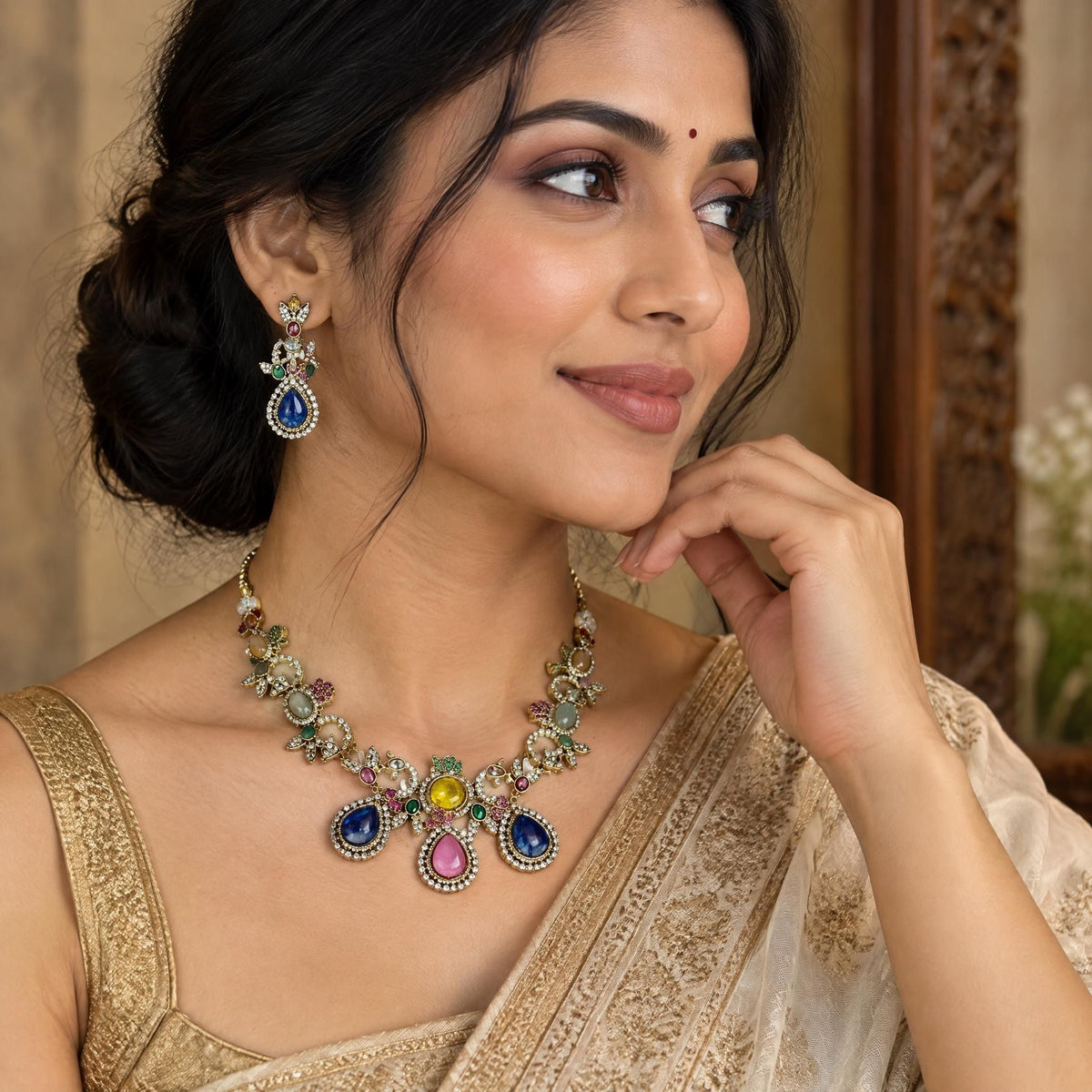 Indian model wearing a multi-colored gemstone necklace and earring set in a three-quarter angle portrait.